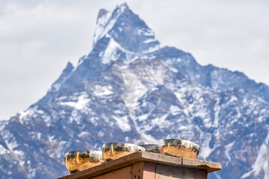 Tibetan singing bowls set against a stunning mountain backdrop in Nepal, showcasing winter serenity.
