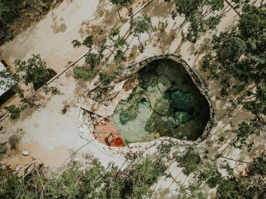 Stunning aerial view of a natural pool nestled in a forest clearing, offering a tranquil retreat.