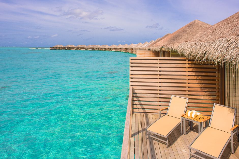 Scenic view of overwater bungalows in a tropical resort, with turquoise waters and clear skies.
