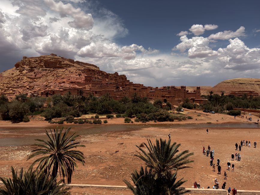 Scenic landscape of Ait Benhaddou, Morocco with dramatic clouds and desert scenery.