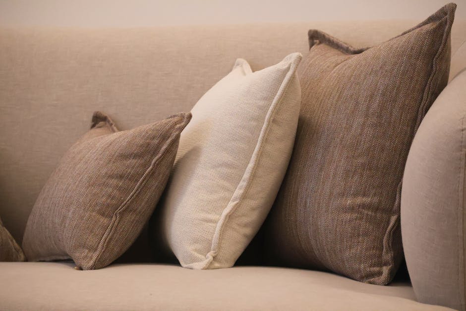 Comfortable sofa with neutral tones of brown and beige throw pillows for a warm living room setting.